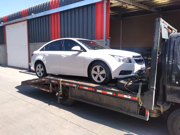 Grúa Torres transportando un automóvil sobre plataforma